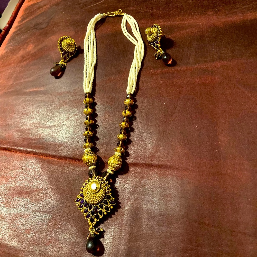 Finely crafted Indian jewelry set. Has seed pearls, gold beads and purple stones